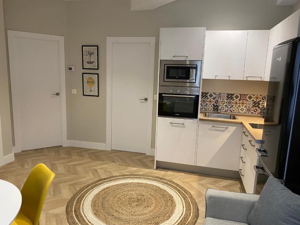 cocina con armarios blancos y alfombra en Apartamento Cielo del Norte VUT LE-933, en León