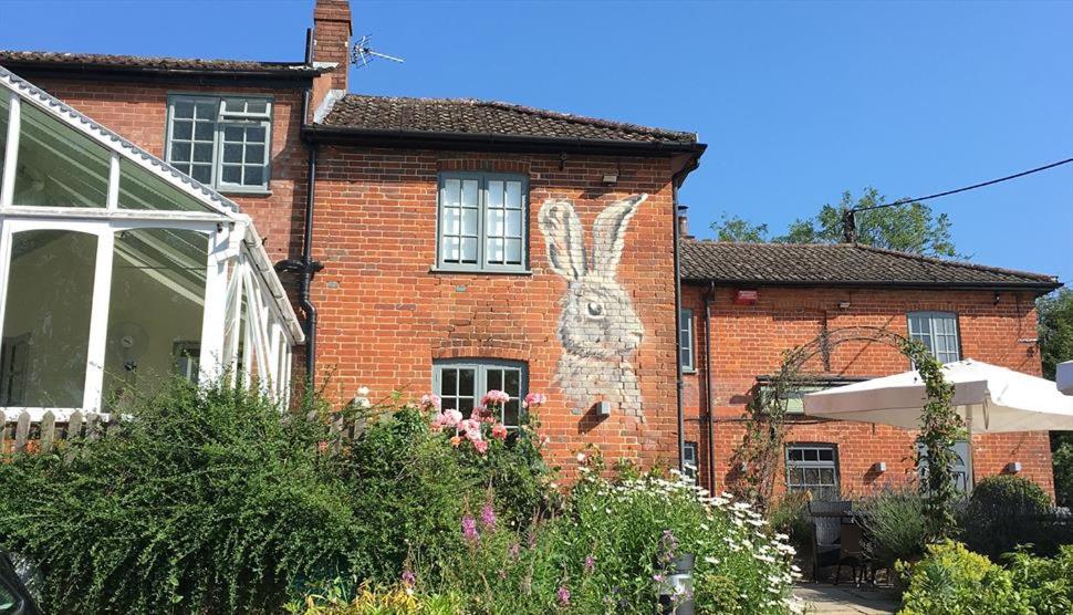 una casa de ladrillo con un conejo pintado a un lado. en Watership Down Inn, en Whitchurch