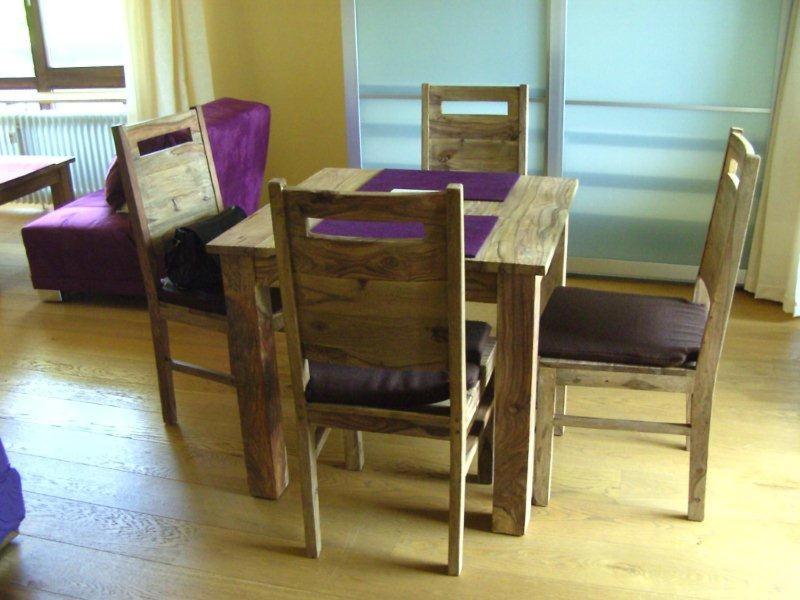 einen Holztisch mit zwei Stühlen und einem Tisch sowie einem Tisch und einem Chairsktop in der Unterkunft Ferienwohnungen Schelhas in Prien am Chiemsee
