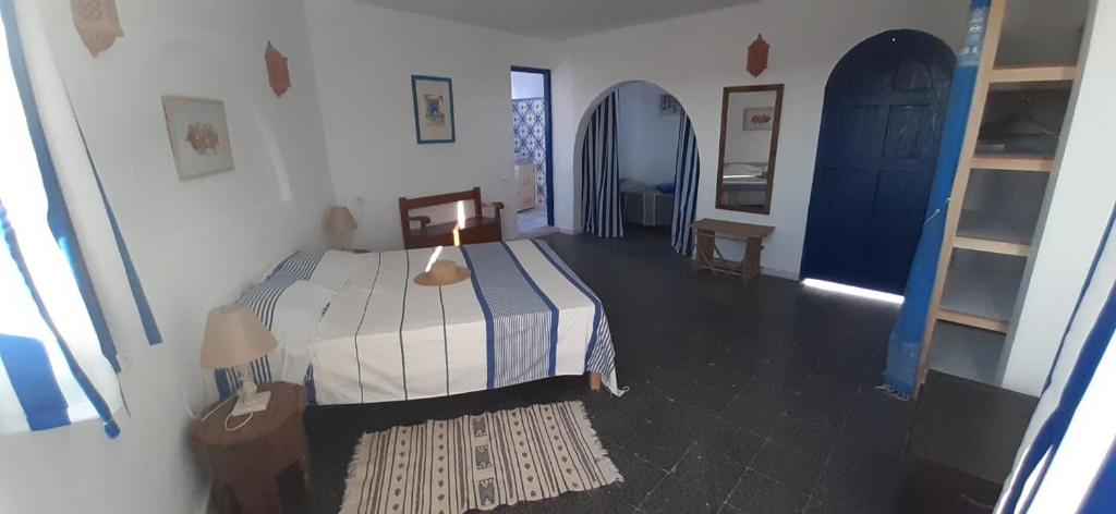 a bedroom with a bed and two blue doors at Dar Chick Yahia Ile De Djerba in Mezrane