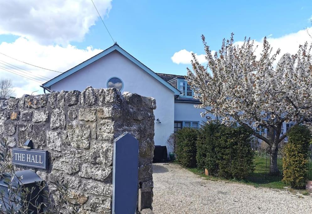 a stone wall with a sign in front of a house at Lovely 2 bed annexe near Salisbury in Salisbury