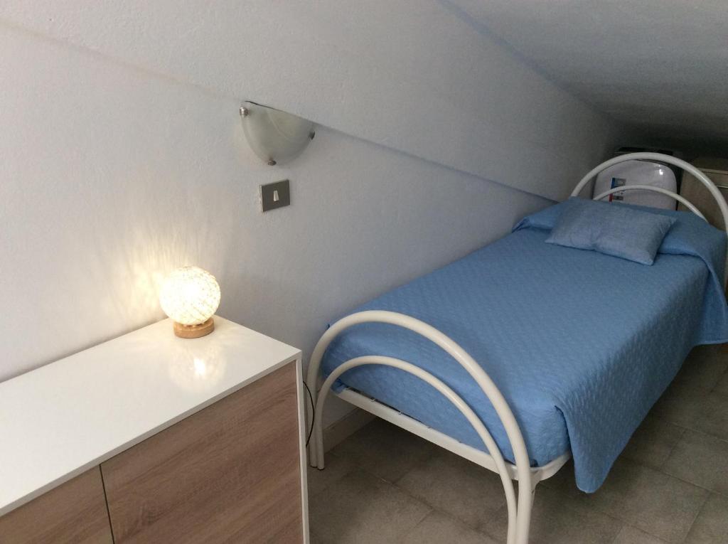 mały pokój z łóżkiem i stołem w obiekcie Creúsa de ma Calasetta w mieście Calasetta