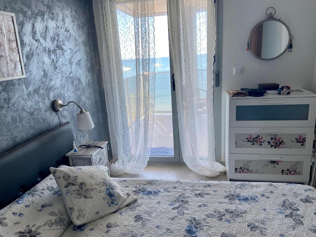 um quarto com uma cama e uma janela com o oceano em Relax em La Manga del Mar Menor
