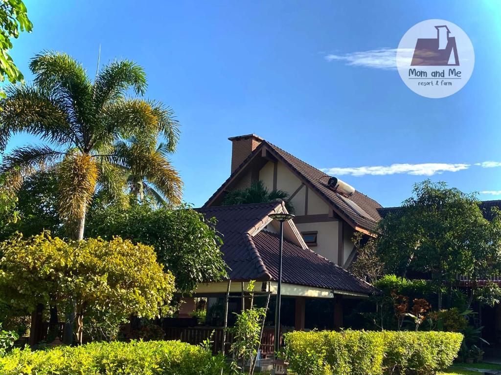 a house with a palm tree in front of it at Mom and Me Resort & Farm in Doi Saket