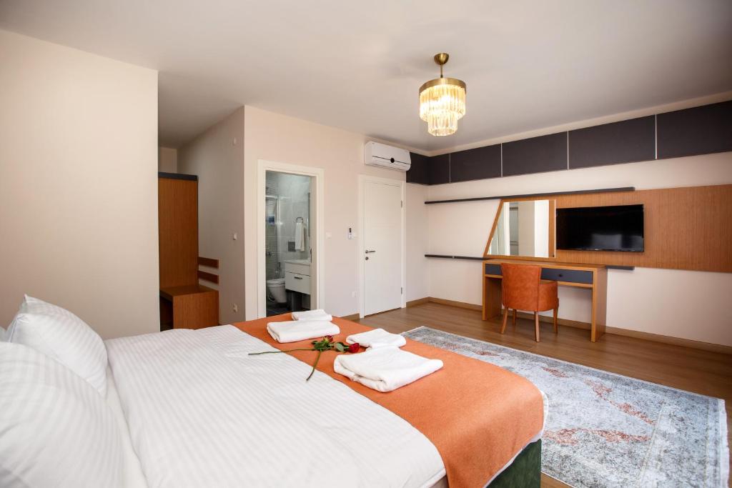 a bedroom with a large white bed and a kitchen at Armoni Deluxe Suites Trabzon in Trabzon