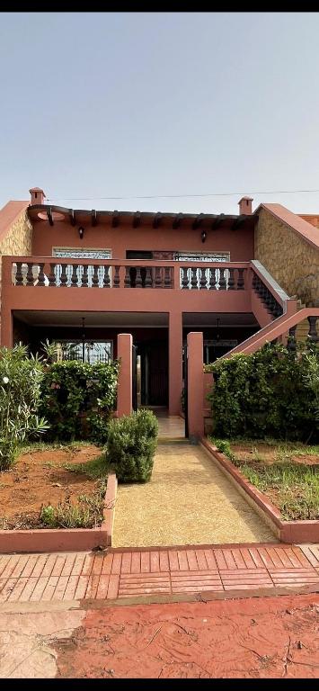 a large building with a walkway in front of it at Villa a tamaris dar bouazza in Casablanca