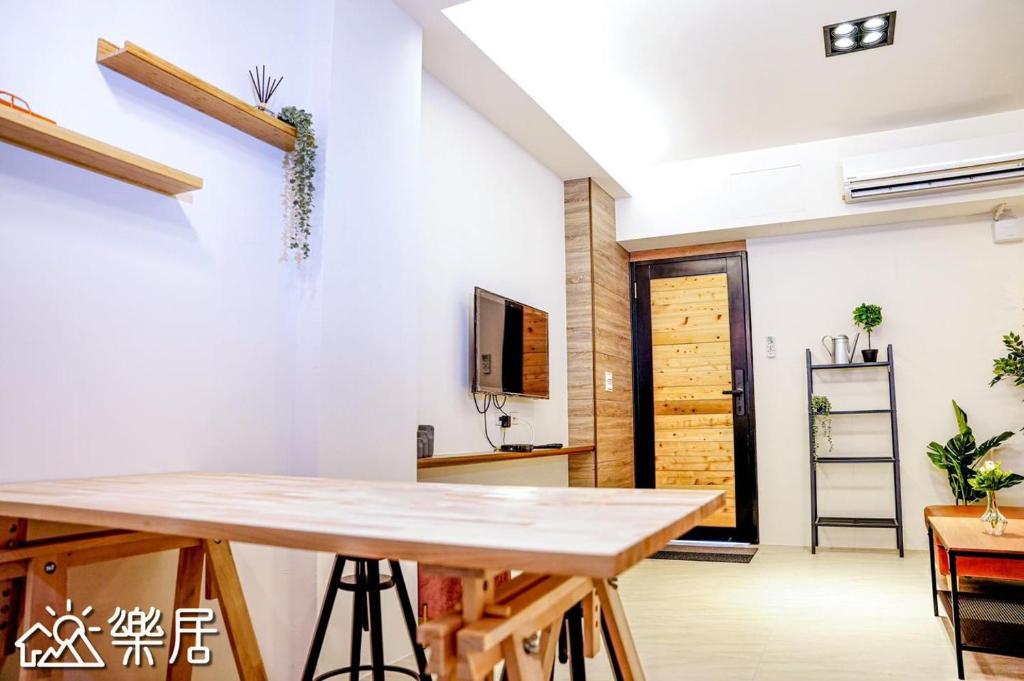 een eetkamer met een tafel en een tv bij Alley-巷弄75包棟民宿 in Yilan