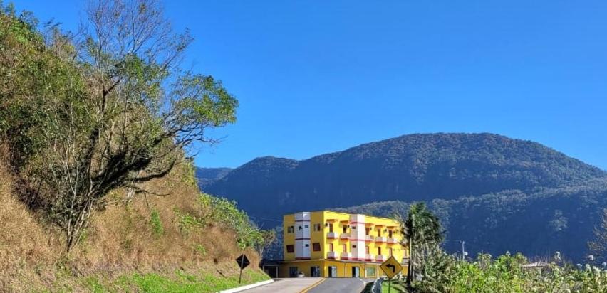 un edificio amarillo al lado de una colina en Hotel Du Rastro, en Lauro Müller