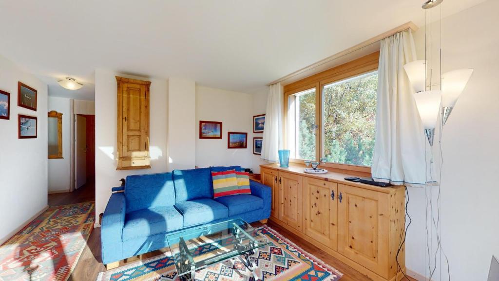 sala de estar con sofá azul y ventana en Truoch en Samedan