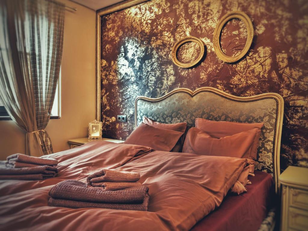 1 dormitorio con 1 cama grande y una pintura en la pared en Тhe Bohemian Lodge-entire house with sauna, en Veliko Tŭrnovo