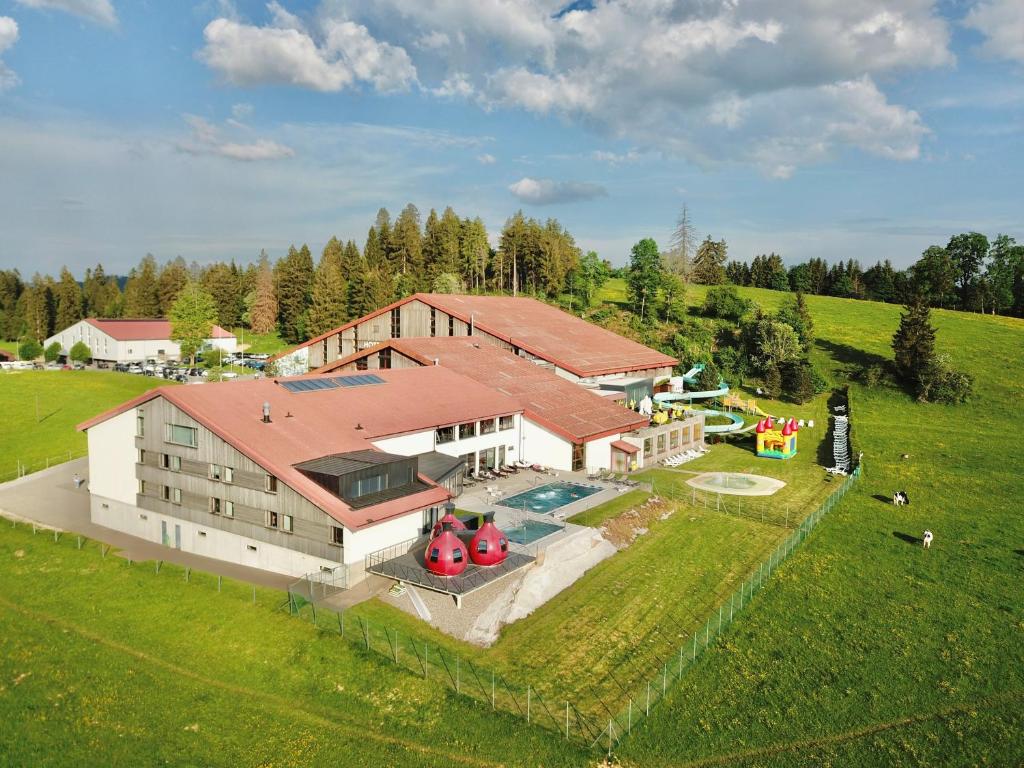 een luchtzicht op een groot huis met een zwembad bij Jura Sport & Spa Resort in Saignelégier