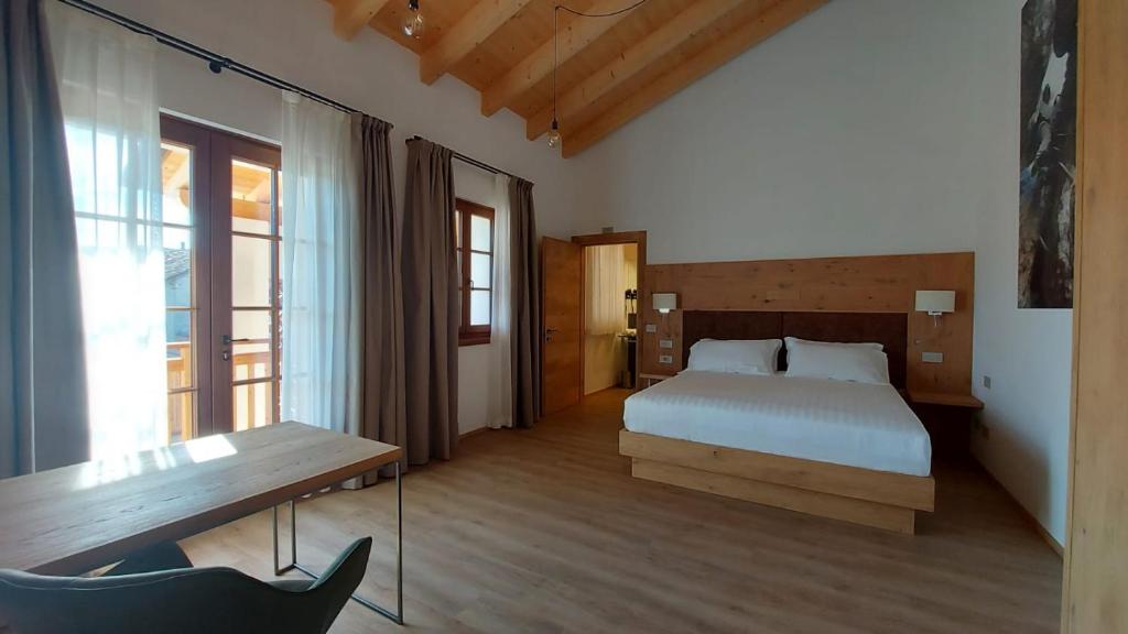 una camera con letto e panca di Corte Varola B&B Zia Marisa a Belluno