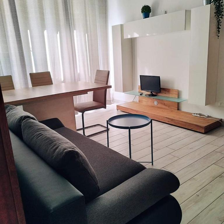 een woonkamer met een bank en een tafel bij Appartamento Galvani in Pordenone