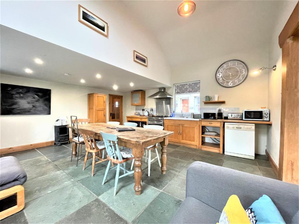 a kitchen and dining room with a table and chairs at Inglefall & Jasmine Cottages in Ingleton 