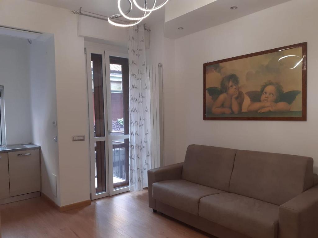 - un salon avec un canapé et un tableau mural dans l'établissement RaffaelloElegante appartamento ideale casa vacanze affari, à Milan