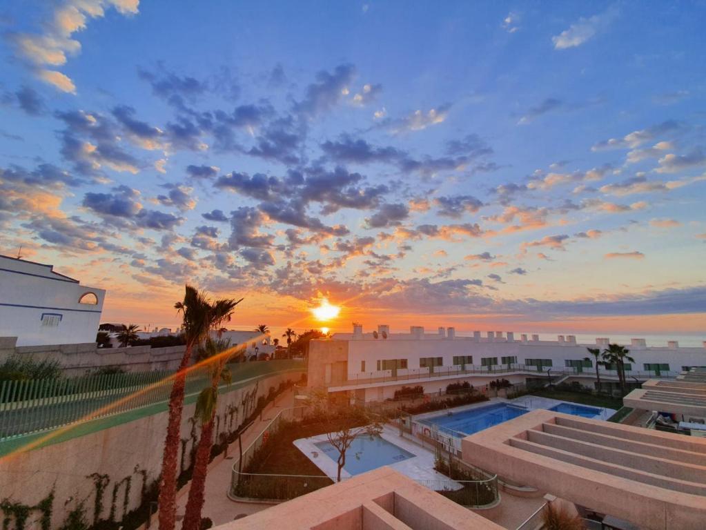 einen Blick auf den Sonnenuntergang vom Balkon eines Resorts in der Unterkunft Apartamento El Sueño Mojácar 1ª Línea de playa in Mojácar