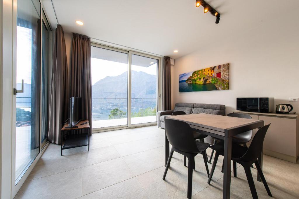 een woonkamer met een tafel en stoelen en een keuken bij Art Vista Lake Como in Nesso