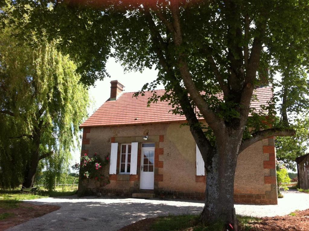 una piccola casa di mattoni con un albero di fronte di Gîte Agonges, 3 pièces, 4 personnes - FR-1-489-36 ad Agonges