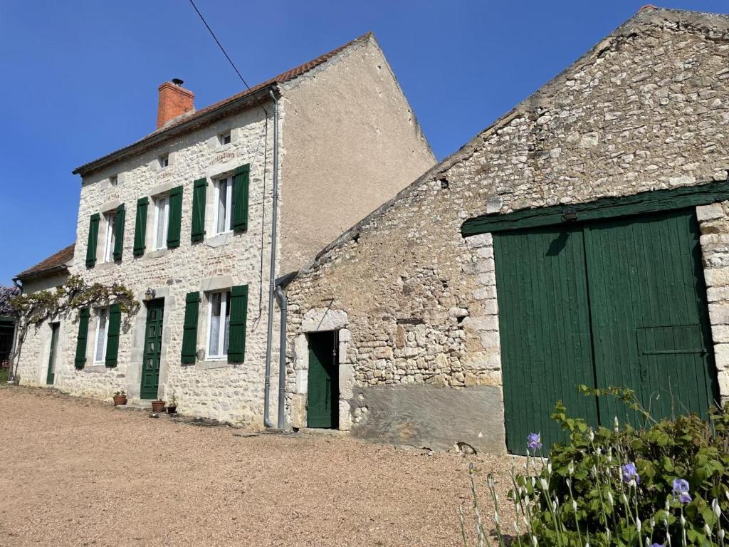 - un vieux bâtiment en pierre avec une porte verte dans l'établissement Gîte Ébreuil, 3 pièces, 4 personnes - FR-1-489-19, à Ébreuil