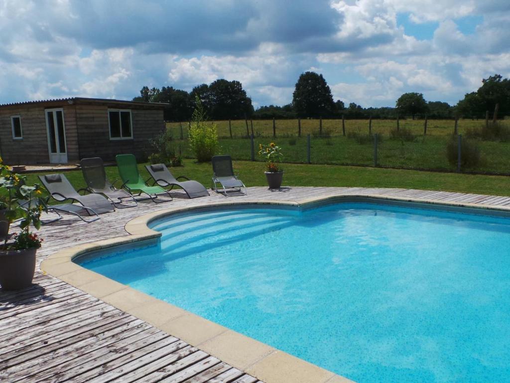 uma grande piscina com cadeiras e um quintal em Gîte Creuzier-le-Neuf, 4 pièces, 6 personnes - FR-1-489-76 em Creuzier-le-Neuf