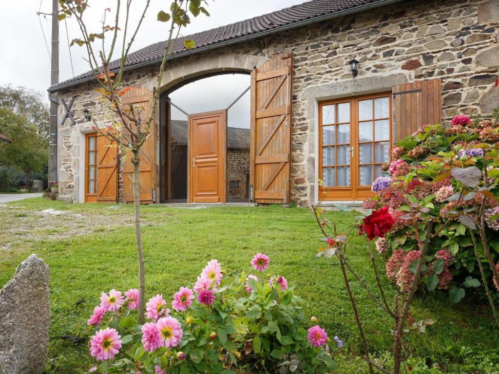 a stone house with an open door and flowers at Gîte Ferrières-sur-Sichon, 4 pièces, 7 personnes - FR-1-489-101 in Ferrières-sur-Sichon