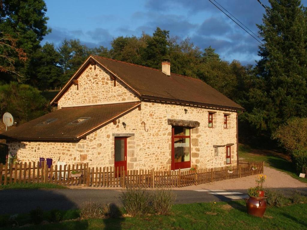 un edificio in pietra con porte rosse e recinto di Gîte Barrais-Bussolles, 5 pièces, 7 personnes - FR-1-489-122 a Barrais-Bussolles