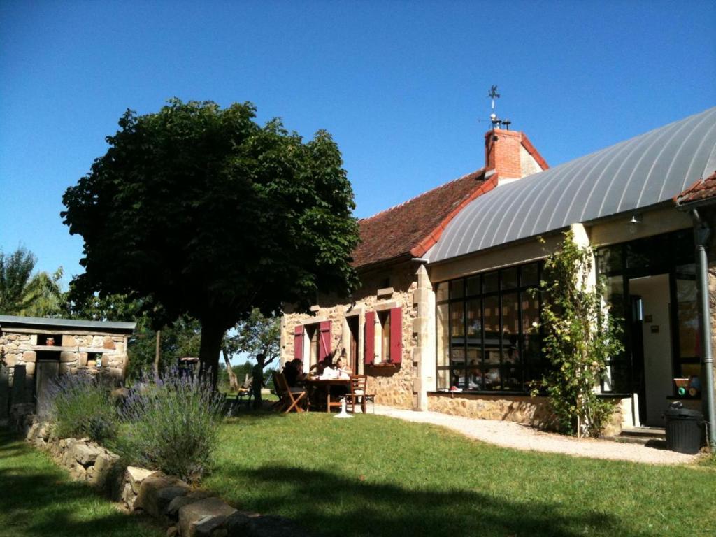 a building with a tree and a table in the yard at Gîte Beaune-d'Allier, 5 pièces, 8 personnes - FR-1-489-228 in Beaune dʼAllier