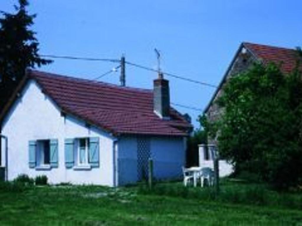 une maison blanche avec un toit rouge et un fauteuil blanc dans l'établissement Gîte Aurouer, 3 pièces, 4 personnes - FR-1-489-258, à Aurouer
