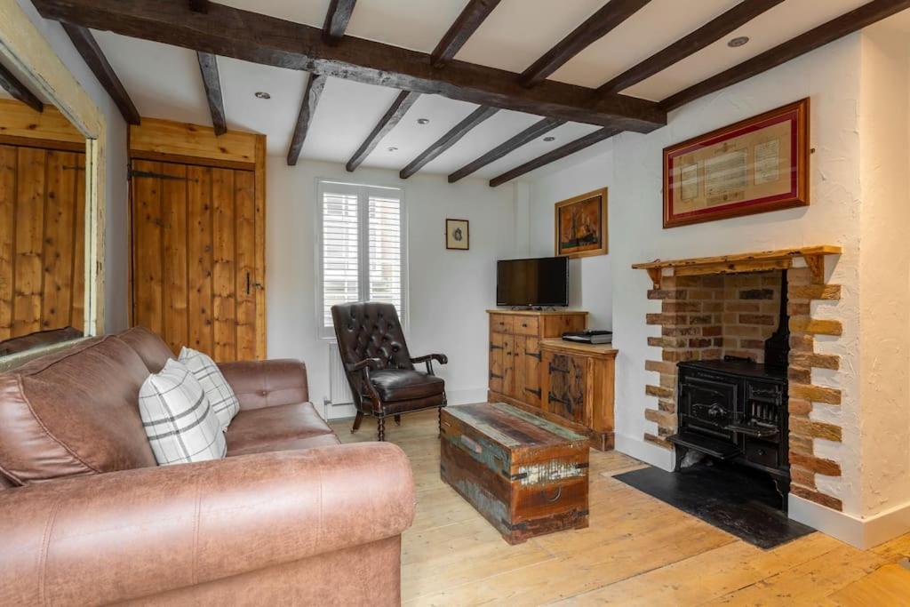 a living room with a couch and a fireplace at Pickwick's Place By The Sea Broadstairs in Broadstairs