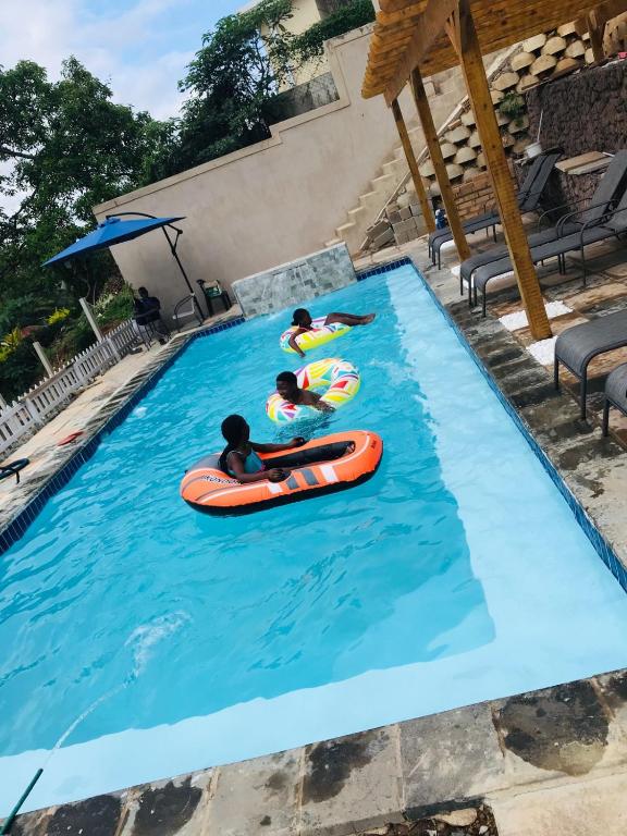 a group of people in a swimming pool on tubes at Ndlovu Palace in Ragbubee