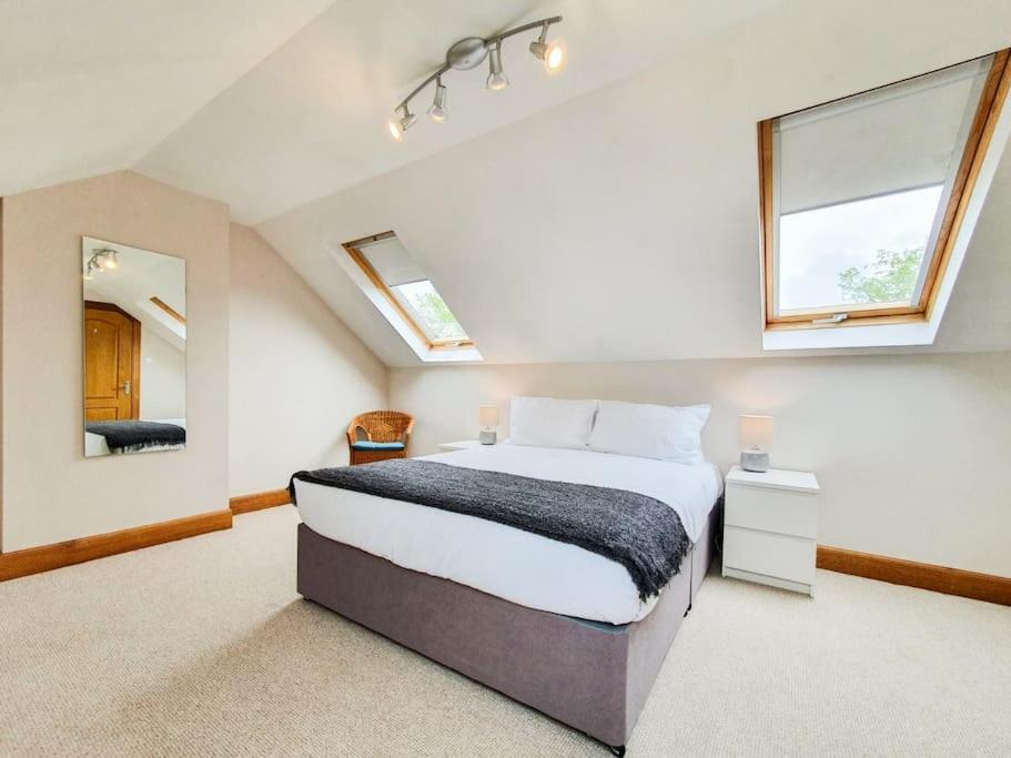 um quarto com uma cama e duas janelas em Parkgate Apartment - Near M90, Amazon, Edinburgh em Rosyth