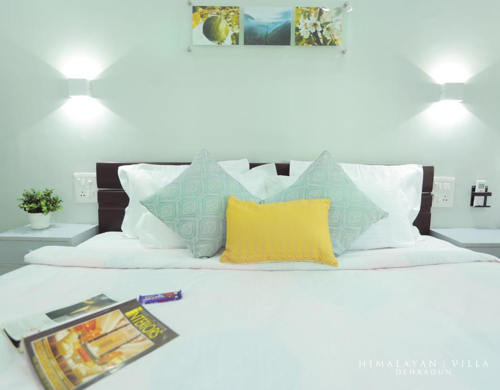 デヘラードゥーンにあるHimalayan Villaのベッド(カラフルな枕、雑誌付)