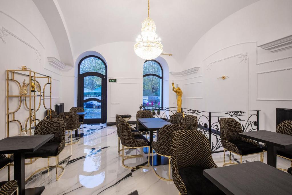 a dining room with tables and chairs and windows at Hotel Vila Central Boutique Satu Mare in Satu Mare
