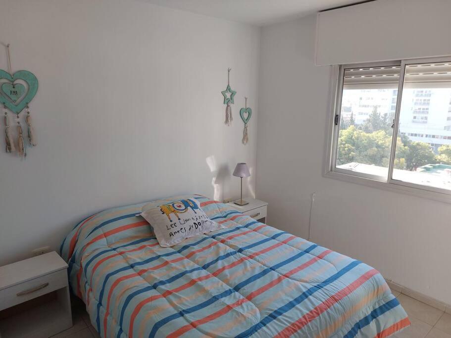 Habitación blanca con cama y ventana en Departamento nuevo en Cordoba en Córdoba