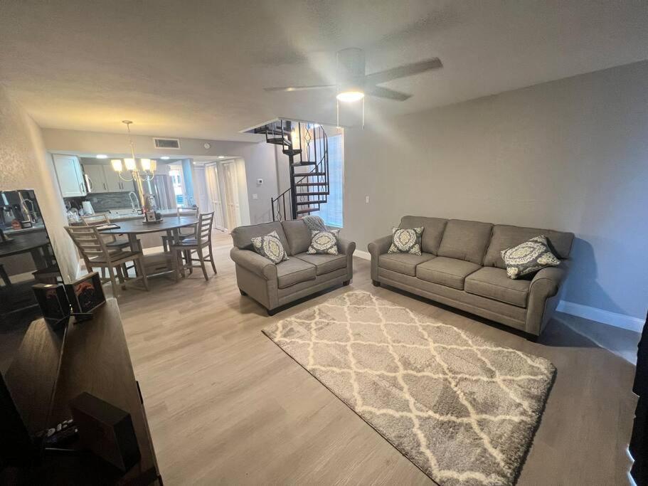 a living room with two couches and a ceiling fan at Cypress Cove Waterfront Townhome with Boat Ramp in Inverness