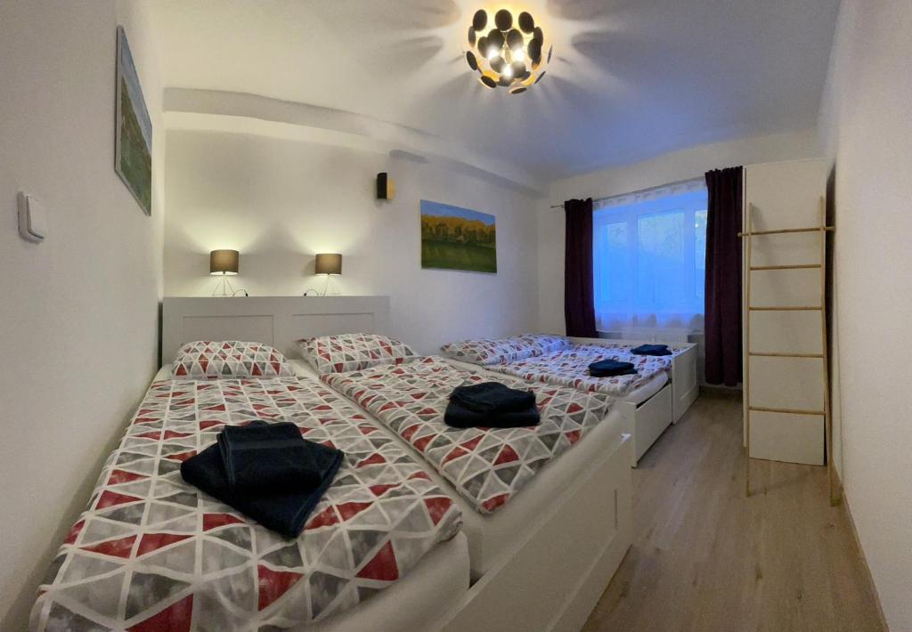 a bedroom with two beds and a large window at Apartmán - Dovolená Žacléř in Žacléř