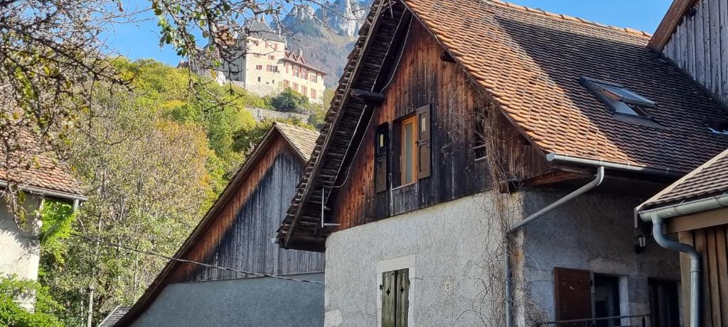 an old house with a mountain in the background at MaisonMenthon in Menthon-Saint-Bernard