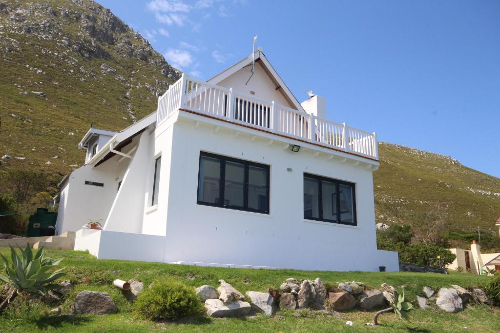 a white house with a hill in the background at Deo-Lize in Bettyʼs Bay