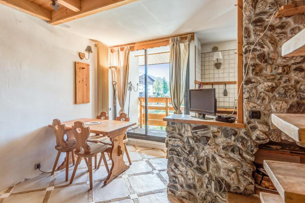 a dining room with a table and a tv at Charming apartment with view on the Mont Blanc - Welkeys in Megève