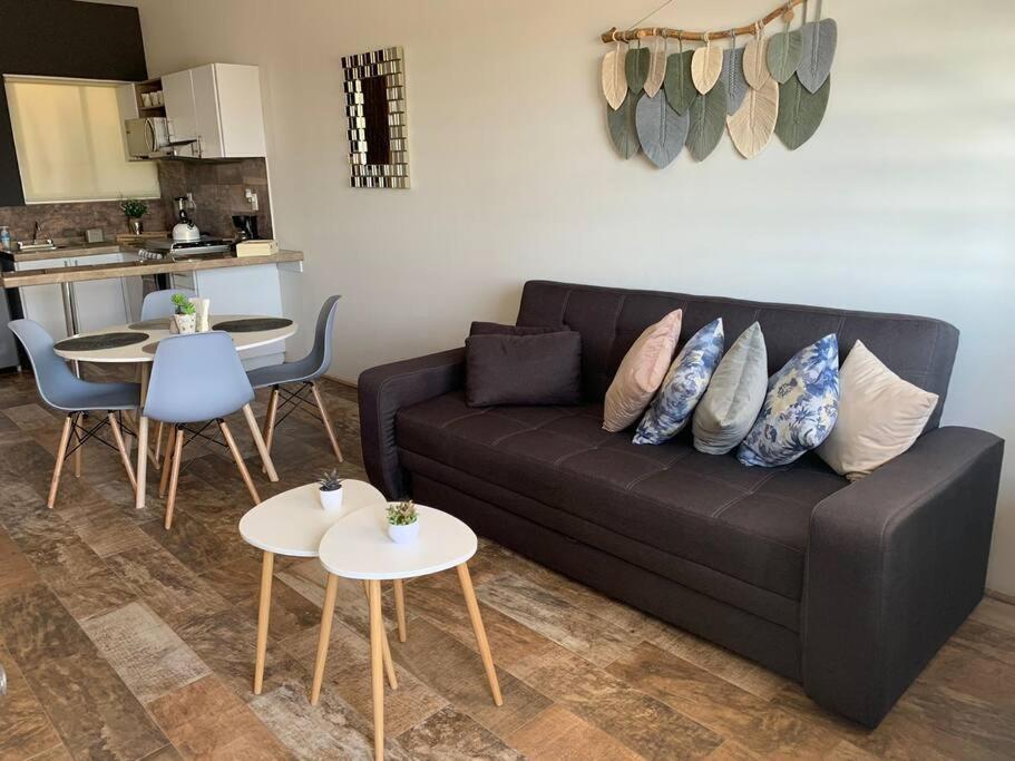 a living room with a black couch and tables at Departamento completo y equipado con 2 habitaciones in León