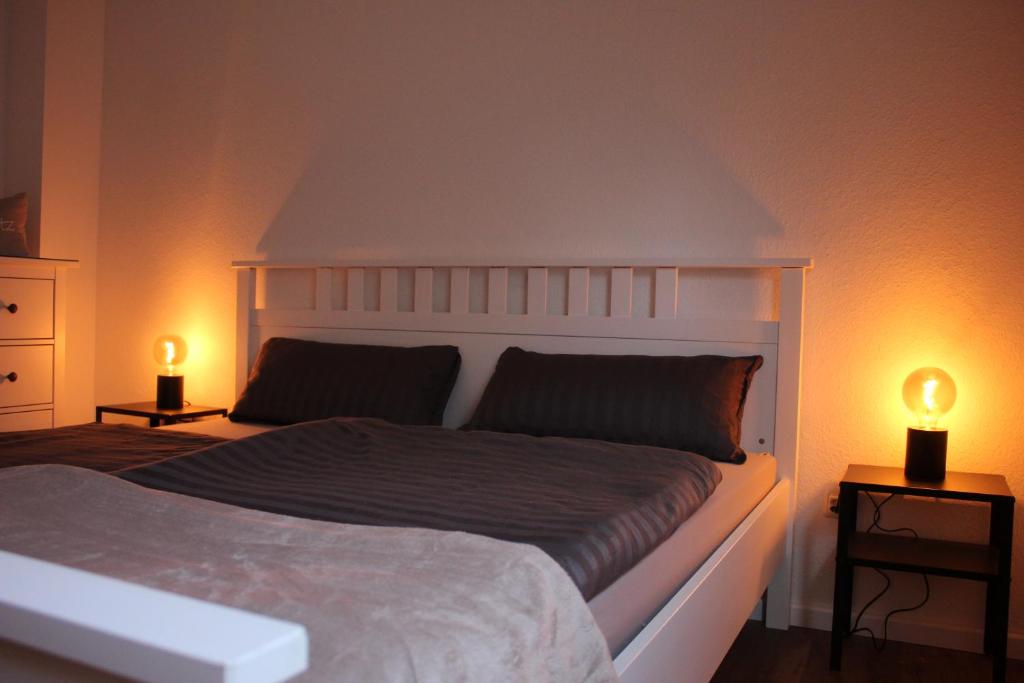 ein Schlafzimmer mit einem großen Bett mit zwei Leuchten in der Unterkunft NordApart - Butjadingen in Butjadingen