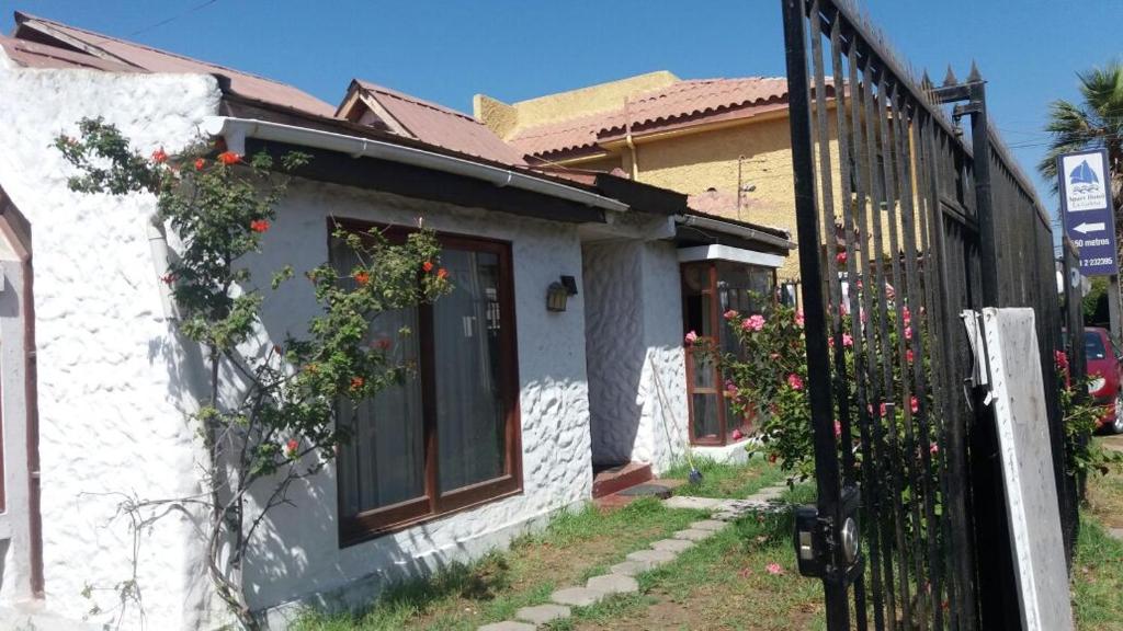 Una casa blanca con una puerta con flores. en Casa Norma santiago 8 personas en Santiago