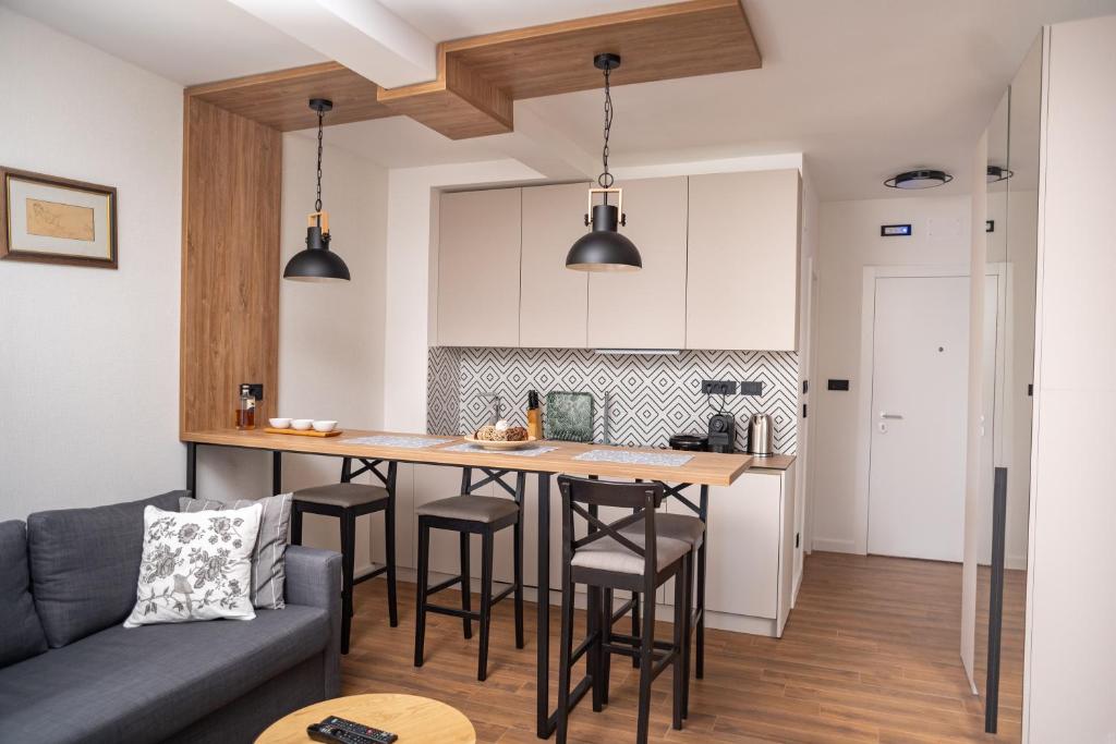 a kitchen with a bar with stools and a couch at Mountain Chalet Kopaonik in Kopaonik