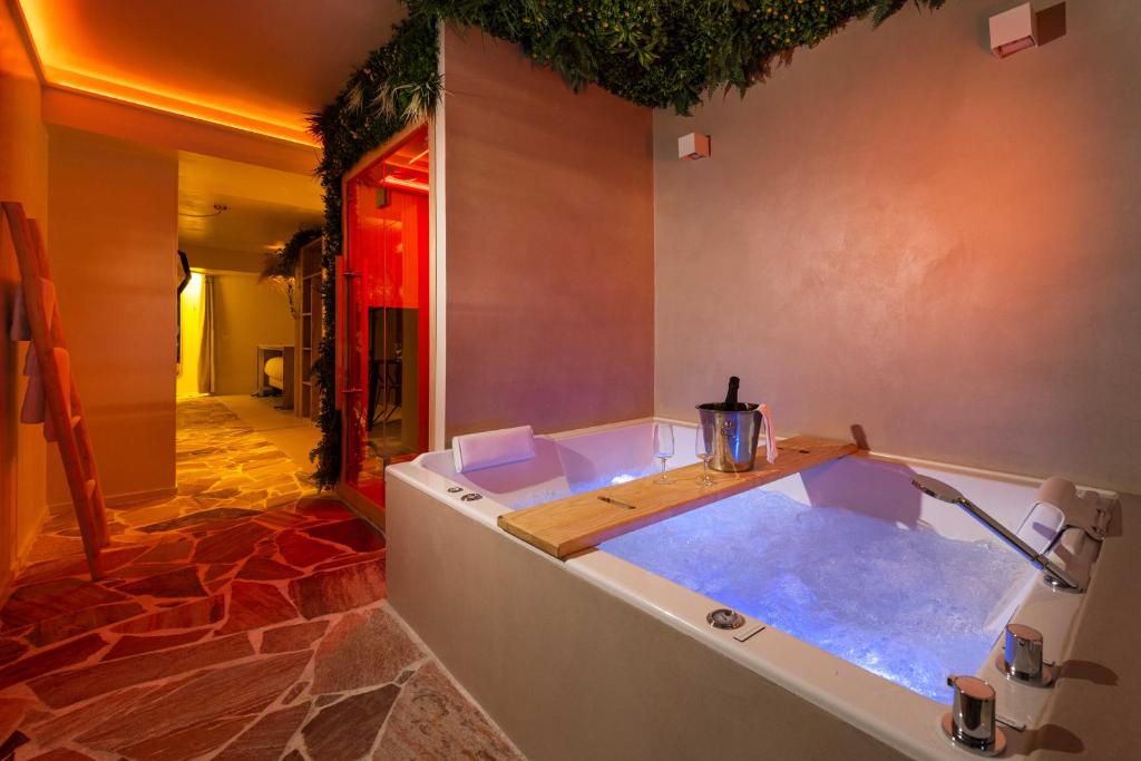a bathroom with a tub filled with water at Minamina, chambre avec jacuzzi privatif in Roquefort-la-Bédoule