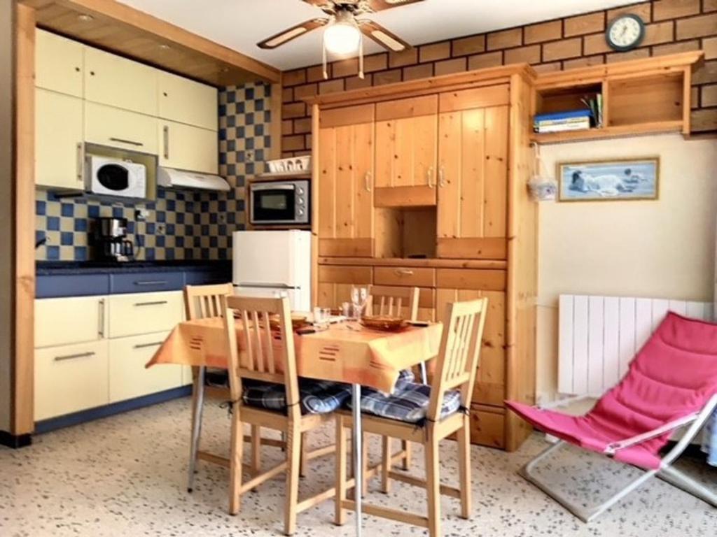 une cuisine avec une table et des chaises en bois dans l'établissement Studio Cosy 2* - Proche Thermes et Étang, Parking Inclus - FR-1-503-103, à Balaruc-les-Bains