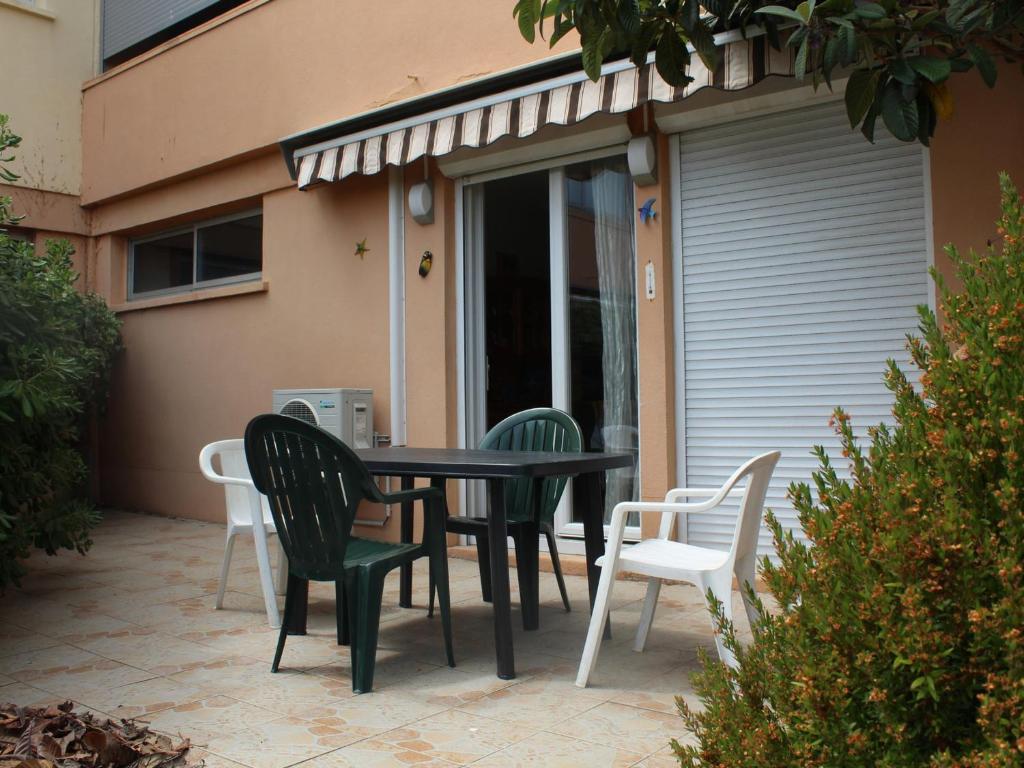 une table et des chaises assises sur une terrasse dans l'établissement Appartement au Bord de l'Étang à Balaruc-les-Bains - Résidence Sécurisée, Climatisé, Pet-Friendly - FR-1-503-122, à Balaruc-les-Bains