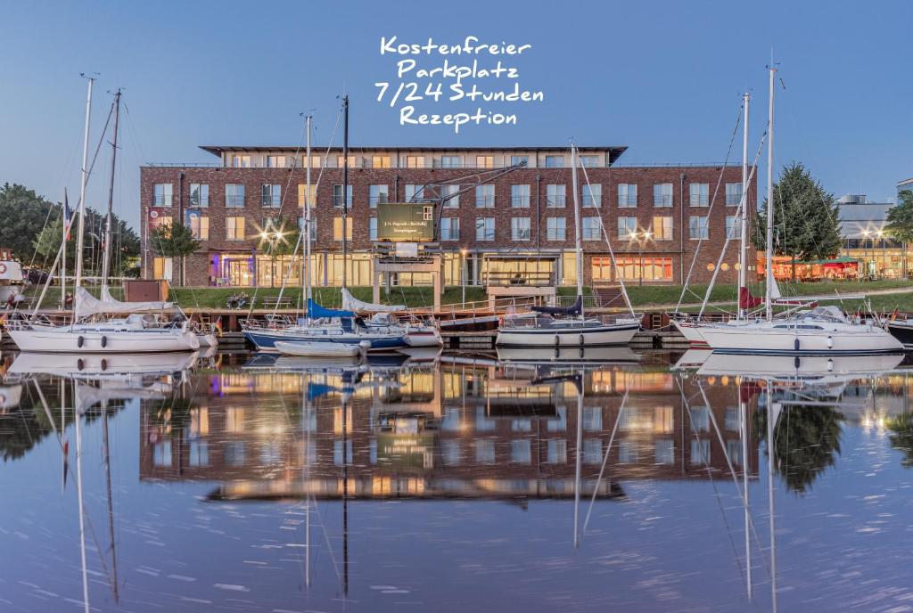 a group of boats docked in front of a building at Hotel Stadthafen Stade in Stade