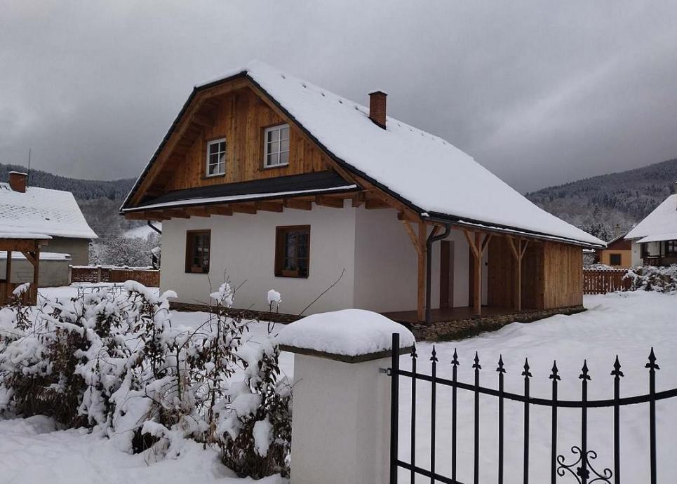 ein schneebedecktes Haus mit einem Zaun in der Unterkunft chalupa Rejhotice in Loučná nad Desnou