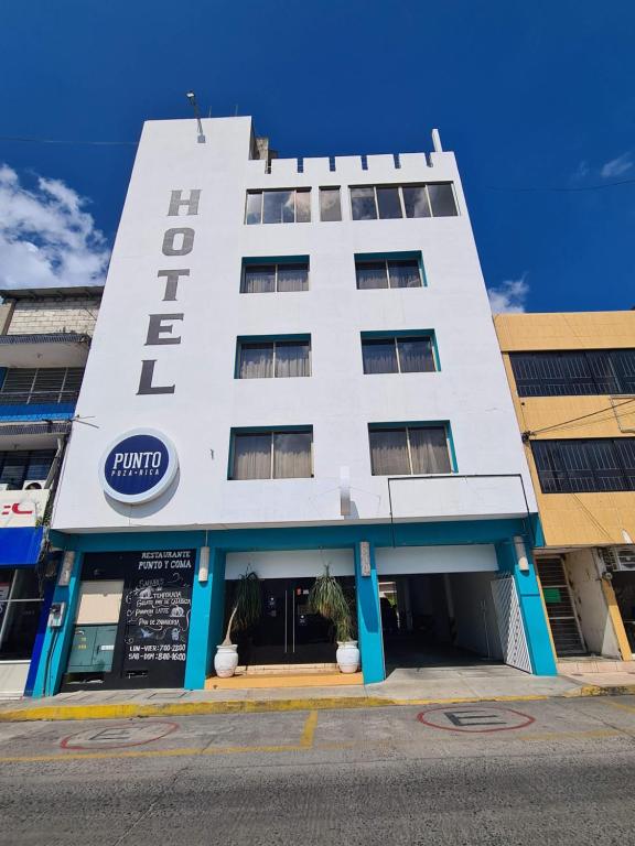 Biały budynek z znakiem hotelu w obiekcie Hotel Punto Poza Rica w mieście Poza Rica