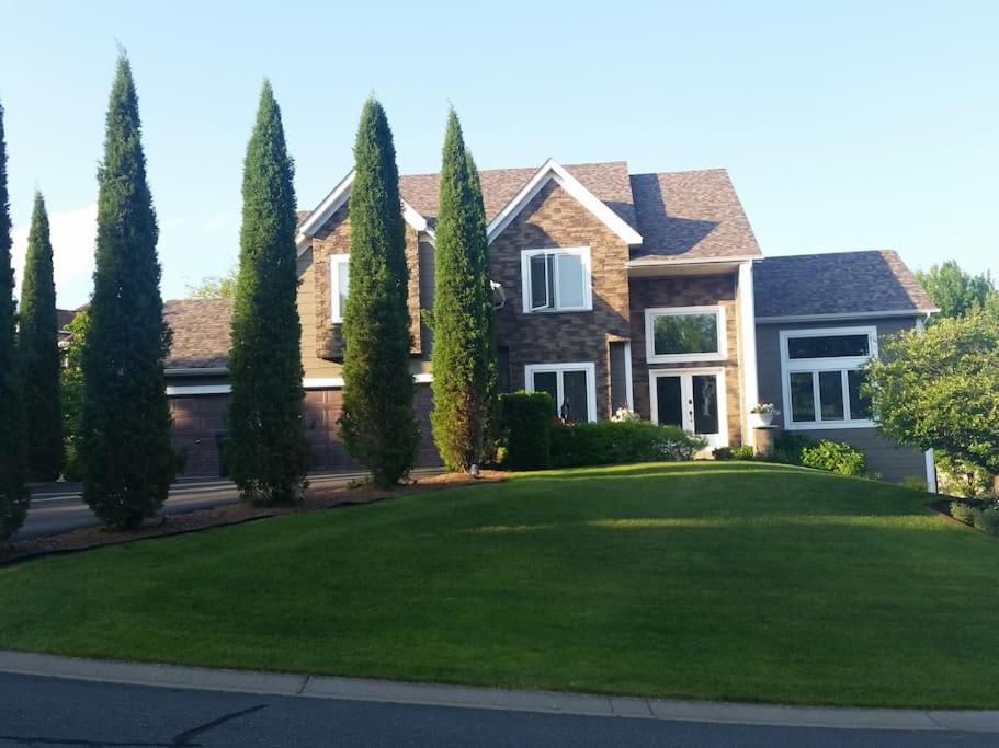 a house with a row of trees in a yard at Lakeville Executive Home with every amenity, prime location in Lakeville